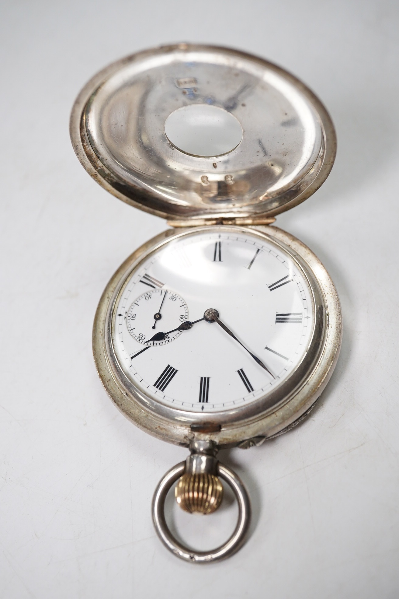 A Swiss 935 white metal half hunter pocket watch, in leather case. Condition - poor to fair